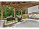 Covered back patio area with space for grilling and entertaining, plus a swing set at 4568 Mantova Dr, Buford, GA 30519