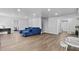 Bright basement featuring wood-look flooring, a comfortable blue couch, and versatile recreational space at 4568 Mantova Dr, Buford, GA 30519