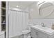 Clean bathroom featuring a gray vanity, round mirror, and a shower with white tile surround and a shower curtain at 4568 Mantova Dr, Buford, GA 30519