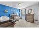 Bright Bedroom with a blue accent wall, crib, and dresser with toys at 4568 Mantova Dr, Buford, GA 30519