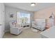 Charming Bedroom with pink accent wall, crib, and comfortable seating area at 4568 Mantova Dr, Buford, GA 30519