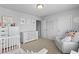 Neutral-toned Bedroom with crib, dresser, and cozy glider chair at 4568 Mantova Dr, Buford, GA 30519