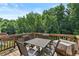 Outdoor deck with wooded views features a dining table and chairs, creating an ideal space for relaxation at 4568 Mantova Dr, Buford, GA 30519