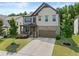 Charming two-story home features a stone and shingle facade, well-manicured lawn, and an attached two-car garage at 4568 Mantova Dr, Buford, GA 30519