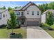 Charming two-story home features a stone and shingle facade, well-manicured lawn, and an attached two-car garage at 4568 Mantova Dr, Buford, GA 30519