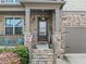 Inviting front porch with stone pillars and trim, steps to front door with HOME sign and comfortable seating at 4568 Mantova Dr, Buford, GA 30519