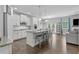 Open-concept kitchen with white cabinets, granite countertops, a large island with seating, and stainless steel appliances at 4568 Mantova Dr, Buford, GA 30519