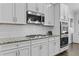 Modern kitchen featuring stainless steel appliances, granite countertops, and white cabinets at 4568 Mantova Dr, Buford, GA 30519