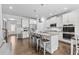Open-concept kitchen with white cabinets, granite countertops, a large island with seating, and stainless steel appliances at 4568 Mantova Dr, Buford, GA 30519