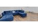 Living room showcases a plush blue sectional with ottoman and wood-look floors, offering comfort and style at 4568 Mantova Dr, Buford, GA 30519