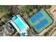 Aerial shot showcases the pool, tennis courts, and playground alongside wooded surroundings at 5470 Beaver Ridge Dr, Cumming, GA 30040