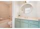 Bathroom featuring blue vanity and a round mirror hanging above the sink at 5470 Beaver Ridge Dr, Cumming, GA 30040