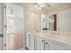 Bright bathroom with double vanity, white cabinets, and a view into the bedroom at 5470 Beaver Ridge Dr, Cumming, GA 30040