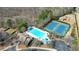 Aerial view showcasing a community pool, tennis courts, playground, and parking lot amid lush trees at 5470 Beaver Ridge Dr, Cumming, GA 30040