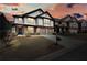 Inviting two-story home with stone accents, dual garage doors, and a landscaped front yard at sunset at 5470 Beaver Ridge Dr, Cumming, GA 30040