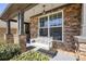 Inviting covered porch with stone pillars, a hanging light fixture, and a charming porch swing at 5470 Beaver Ridge Dr, Cumming, GA 30040