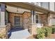 Cozy covered porch with stone accents, a hanging light fixture, and a relaxing porch swing at 5470 Beaver Ridge Dr, Cumming, GA 30040