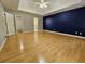 Spacious bedroom with hardwood floors, a tray ceiling with a fan, and a stylish accent wall at 105 Old Hickory Pointe, Mcdonough, GA 30252