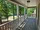 Inviting front porch featuring white railings and wood flooring, offering a scenic view of the neighborhood at 105 Old Hickory Pointe, Mcdonough, GA 30252