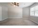 Spacious carpeted bedroom with a window, ceiling fan, and neutral walls at 5292 Mountain Village Ct, Stone Mountain, GA 30083
