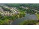 Aerial view of neighborhood with pond, mature trees, and well-maintained landscaping at 6370 Stillwood Ln, Cumming, GA 30041