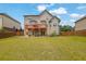 Spacious backyard featuring a deck, covered patio, and lush green lawn at 6370 Stillwood Ln, Cumming, GA 30041
