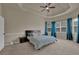 Spacious bedroom featuring a tray ceiling, carpet floors, and large windows with curtains at 6370 Stillwood Ln, Cumming, GA 30041