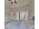 Comfortable bedroom featuring tray ceilings, carpeted floors, and access to a private bathroom at 6370 Stillwood Ln, Cumming, GA 30041