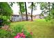 Landscaped backyard with manicured lawn, mature trees, spacious deck and beautiful flowers in bloom at 830 Cramac Dr, Lawrenceville, GA 30046