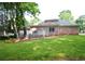Expansive backyard with manicured lawn, mature trees, spacious deck and brick house at 830 Cramac Dr, Lawrenceville, GA 30046