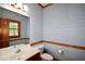 Charming bathroom with floral wallpaper, a wooden framed mirror, and classic fixtures at 830 Cramac Dr, Lawrenceville, GA 30046