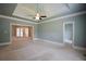Spacious bedroom featuring a tray ceiling, ceiling fan, and open access to a sunroom, creating a bright and airy atmosphere at 830 Cramac Dr, Lawrenceville, GA 30046