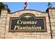 Close-up of the entrance sign for Cramac Plantation featuring stone pillars and an American flag at 830 Cramac Dr, Lawrenceville, GA 30046
