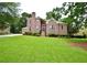 Charming two-story brick home with manicured lawn, mature trees, and beautiful landscaping at 830 Cramac Dr, Lawrenceville, GA 30046