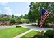 Beautiful street view featuring mature trees, manicured lawns, and traditional homes with an American flag at 830 Cramac Dr, Lawrenceville, GA 30046