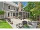 A spacious backyard with a large stone patio, an outdoor seating area, a screened-in porch, and mature landscaping at 120 Forest Breeze Cv, Alpharetta, GA 30022