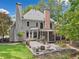 Expansive backyard featuring a large patio, screened-in porch, lush greenery, mature trees, and a charming water feature at 120 Forest Breeze Cv, Alpharetta, GA 30022