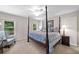 Bedroom featuring natural light from the windows and a four-poster bed with a blue comforter at 120 Forest Breeze Cv, Alpharetta, GA 30022