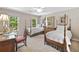 Bedroom with two four-poster beds, natural light from the windows, and neutral carpet at 120 Forest Breeze Cv, Alpharetta, GA 30022