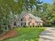 Beautiful two-story brick home with manicured lawn and mature trees at 120 Forest Breeze Cv, Alpharetta, GA 30022