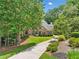 Beautiful two-story brick home with a manicured front lawn, mature trees, and a curved driveway leading to the entrance at 120 Forest Breeze Cv, Alpharetta, GA 30022