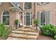 Charming front porch with stone steps, elegant planters, and brick facade at 120 Forest Breeze Cv, Alpharetta, GA 30022