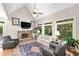 Cozy living room with a stone fireplace, vaulted ceilings, and ample natural light from large windows at 120 Forest Breeze Cv, Alpharetta, GA 30022