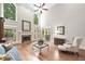 Spacious living room with fireplace, tall windows, and hardwood floors at 120 Forest Breeze Cv, Alpharetta, GA 30022