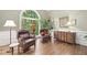 Comfortable sitting room featuring hardwood floors, a large arched window, and tasteful decor at 120 Forest Breeze Cv, Alpharetta, GA 30022