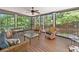 Relaxing screened porch with wicker furniture and views of the surrounding trees at 120 Forest Breeze Cv, Alpharetta, GA 30022