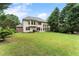 Large backyard featuring a stone patio, expansive lawn, and mature trees at 1055 Beacon Hill Xing, Alpharetta, GA 30005