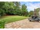 Backyard with a large grassy area and a stone patio featuring two lounge chairs with an umbrella at 1055 Beacon Hill Xing, Alpharetta, GA 30005