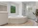 Bright bathroom featuring a soaking tub and a glass-enclosed shower, offering a serene retreat at 1055 Beacon Hill Xing, Alpharetta, GA 30005
