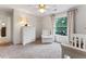 Bedroom with a white crib, chair, and dresser, featuring a neutral color palette and natural light at 1055 Beacon Hill Xing, Alpharetta, GA 30005